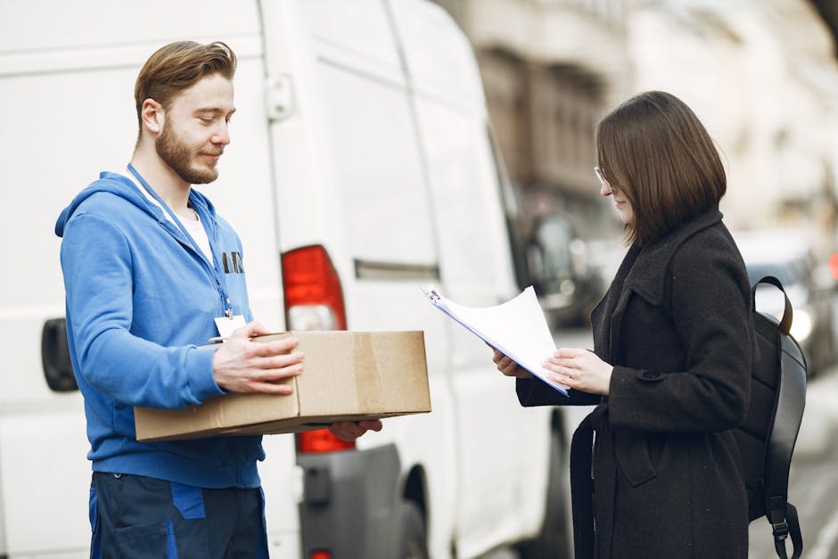 A courier hands over a package to a woman client on a city street, facilitating delivery service.